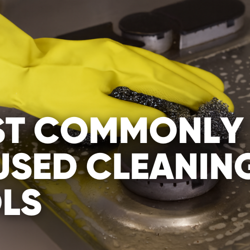 A person cleaning a surface with a sponge and wearing yellow gloves.