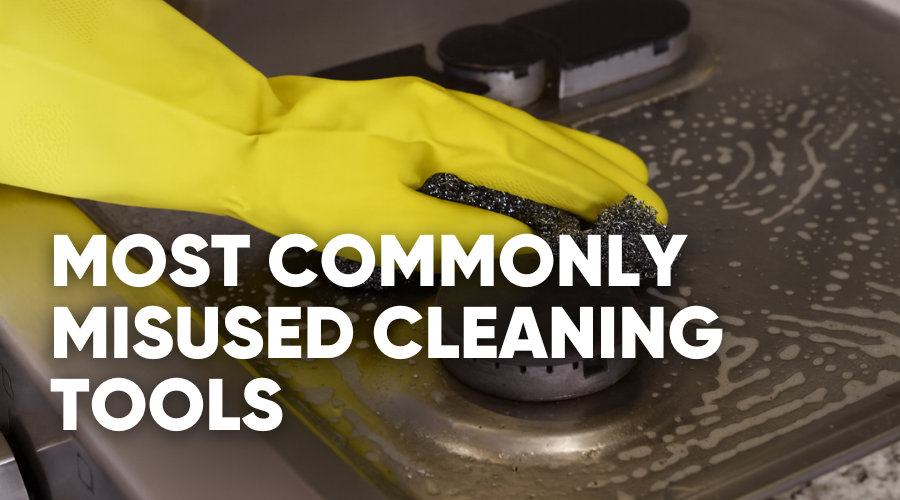 A person cleaning a surface with a sponge and wearing yellow gloves.