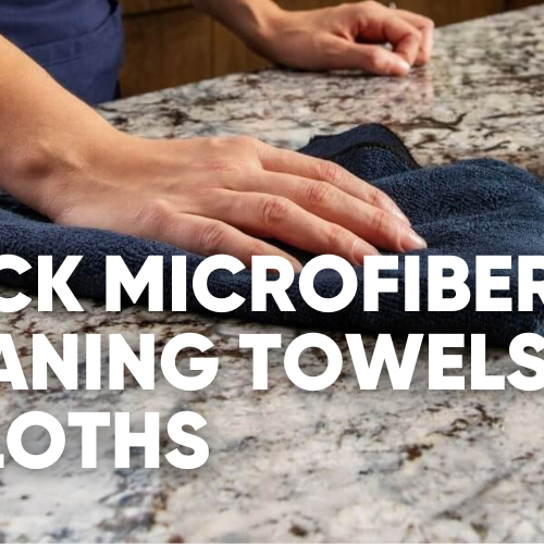 Person wiping a granite surface with a black microfiber towel.