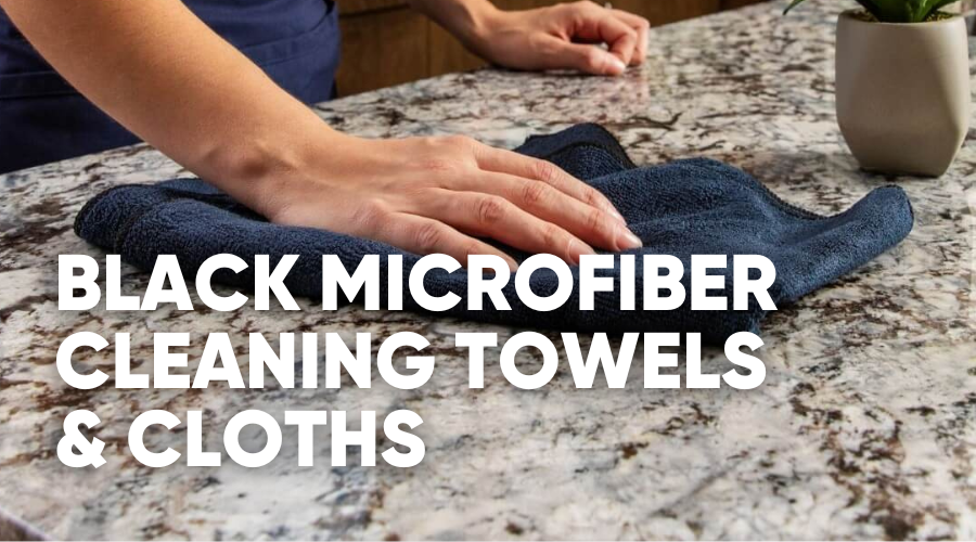 Person wiping a granite surface with a black microfiber towel.