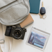 a lens cloth and camera spilling out of a backpack on a table