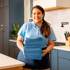 cleaner holding a stack of microfiber towels