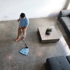 man mopping concrete with a blue microfiber tube mop