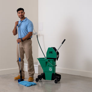 man mopping concrete with a blue microfiber tube mop and green bucket