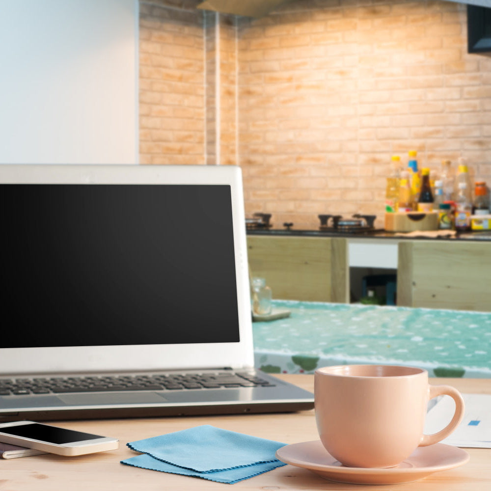 silk lens cloth on a desk with phone, coffee cup, and laptop