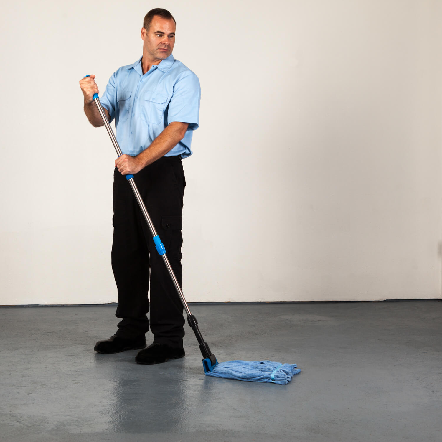 Janitor using rough floor mop on concrete