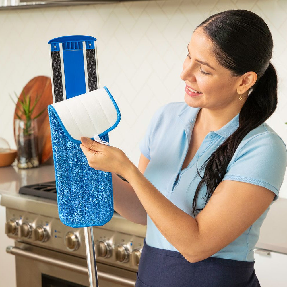 woman removing a microfiber flat wet mop pad from a mop frame
