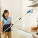 a woman washing a tiled wall with a microfiber flat mop